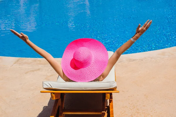 모자는 수영장에 의해 일 안락에 일광욕으로 행복 한 여자 — 스톡 사진