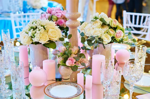 Inrichting van kaarsen en bloemen aan de bruiloft tafel in een restaurant — Stockfoto