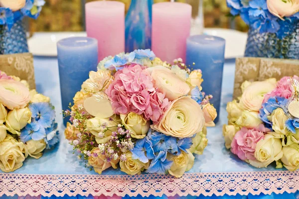 Inrichting van kaarsen en bloemen aan de bruiloft tafel in een restaurant — Stockfoto