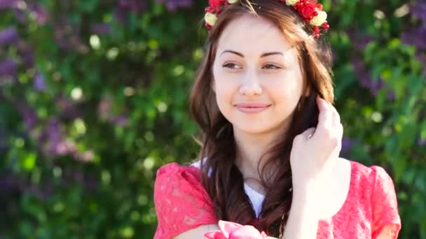 Mujer en un vestido rojo con una corona en el jardín de primavera — Vídeo de stock