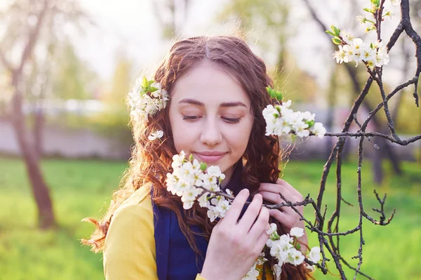 Unga vackra kvinnan i den blommande vår trädgården — Stockfoto