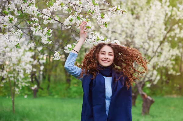 Junge Frau im blühenden Frühlingsgarten spaziert — Stockfoto