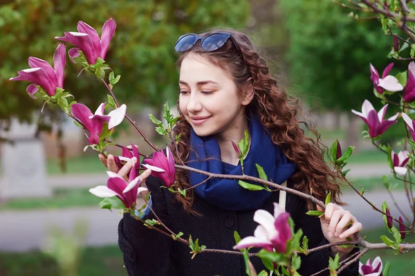 Unga vackra kvinnan i den blommande vår trädgården — Stockfoto