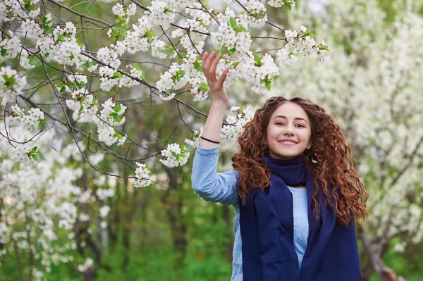 Young woman in the blossoming spring garden walks — Stock Photo, Image