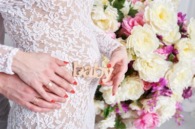 Hamile kadın ve onun kocası bir kalp şeklinde ellerimi