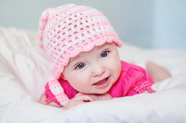 Newborn baby girl in pink knitted hat on the bed — Stock Photo, Image