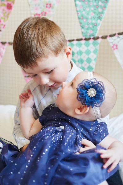 Happy little boy playing with a baby, his sister indoors — Stock Photo, Image