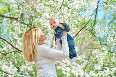 Bahar çiçeği bahçe içinde genç anne ile küçük oğlu