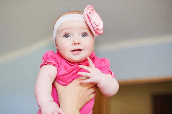 Portret van een schattig klein babymeisje met roze boog bloem op haar hoofd — Stockfoto