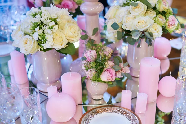 Tafel set voor bruiloft receptie met kaarsen en bloemen boeketten — Stockfoto