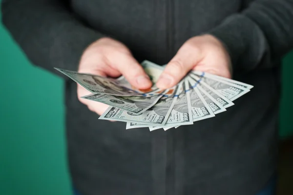 Mano de hombre dando billetes de 100 dólares en estudio — Foto de Stock