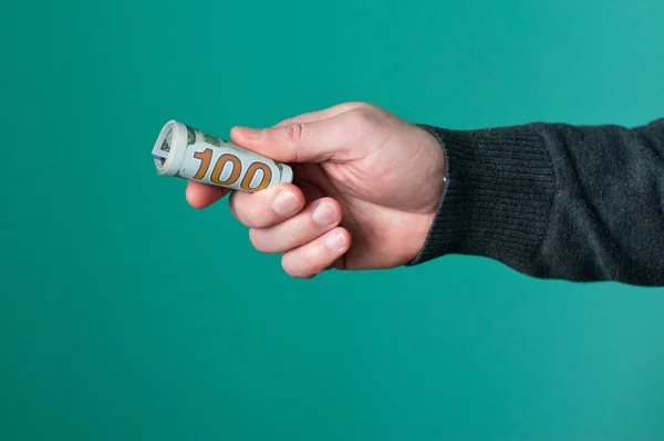 Lidská ruka drží srolovaný papír dolar měny — Stock fotografie