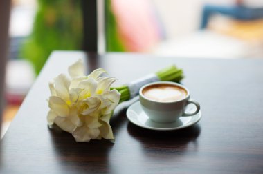 masaya kafede kahve ve buket çiçek fincan