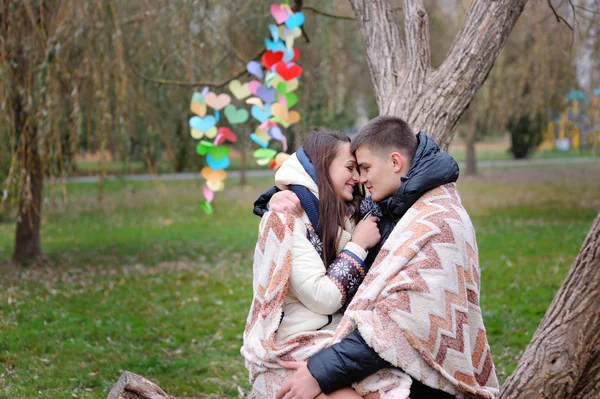 Ζευγάρι στην αγάπη κάτω από κουβέρτα θερμαίνεται φθινόπωρο πάρκο — Φωτογραφία Αρχείου