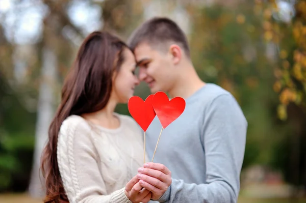 Coppia amorevole con cuore rosso nel parco autunnale. concetto di amore — Foto Stock