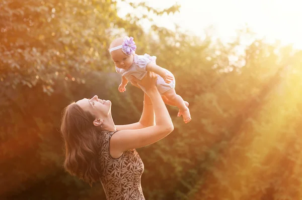 Giovane madre che tiene la figlia tra le braccia — Foto Stock