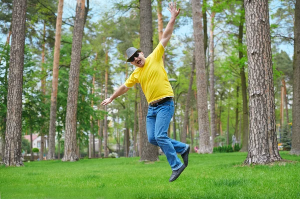 Netter Mann springt an sonnigem Tag im Park — Stockfoto