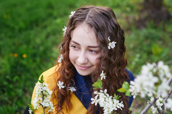 Close up de bela jovem mulher andando em um jardim de primavera florescente — Fotografia de Stock