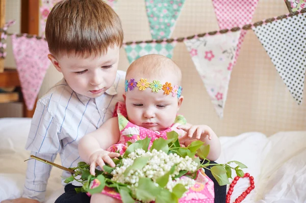 Süße kleine Bruder und Schwester sitzen auf dem Bett in ihrem Zimmer — Stockfoto