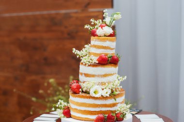 üç katmanlı düğün pastası masada çilek ile