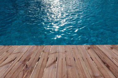 Eski ahşap zemin ve masmavi bir deniz yüzme havuzunda