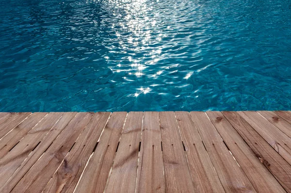 Piso de madeira velho e água azul na piscina — Fotografia de Stock
