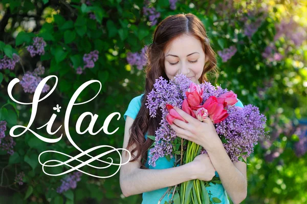 Piękna kobieta z bukietem kwiatów wiosna park i słowo liliowy — Zdjęcie stockowe