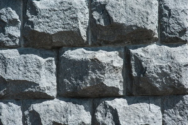 Old wall of large black different stones surface background — Stock Photo, Image