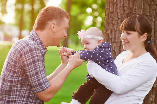 Concepto de paternidad familiar - padre madre feliz y niña jugando en el parque de verano —  Fotos de Stock