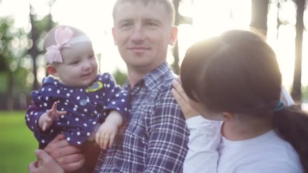 Happy young family spending time together outside in green summer park — Stock Video