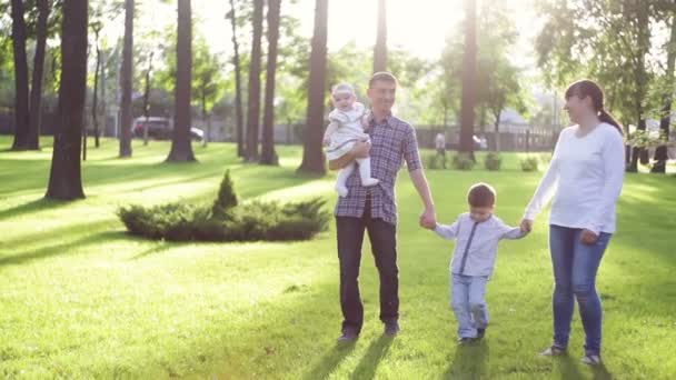 Boldog fiatal család tölteni az időt együtt kívül a zöld nyári park — Stock videók