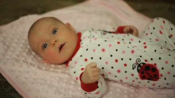 Pequena menina deitada em uma cama — Vídeo de Stock