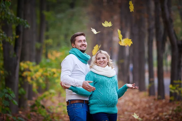 Husband and pregnant wife are walking in autumn park — Stock Photo, Image