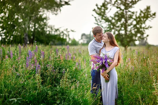 Krásná žena s dlouhými vlasy a šťastný muž, objímat v poli — Stock fotografie