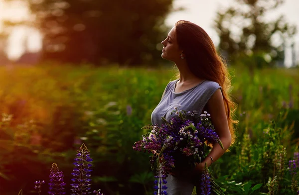 Женщина с букетом голубых люпиновых цветов — стоковое фото