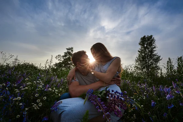 Jovem casal bonito feliz sentado no prado verde — Fotografia de Stock