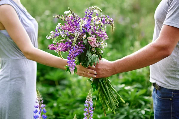 Conceito familiar. Mãos de homem dá a sua esposa um buquê de flores silvestres — Fotografia de Stock