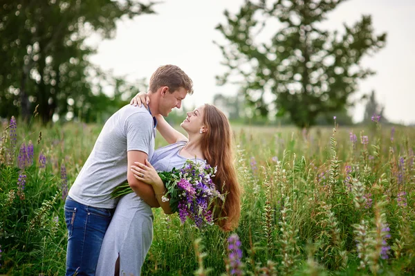 Retrato de la joven pareja de moda con estilo en el campo mirando el uno al otro —  Fotos de Stock