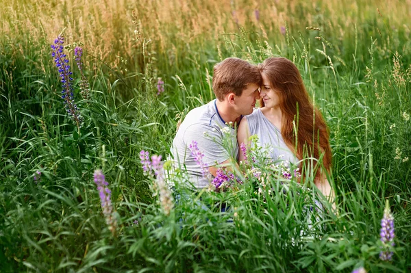 Portrait of young stylish fashion couple in field looking on each other — Stock Photo, Image