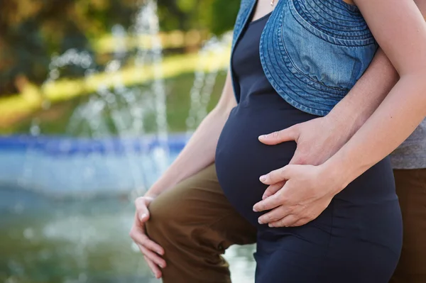 妊娠中の女性と夫の腹に手を繋いでいます。 — ストック写真
