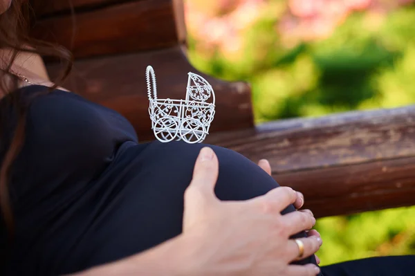 Vit toy barnvagn på magen av gravid kvinna — Stockfoto