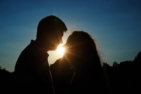 Silueta muž a žena na pozadí slunce — Stock fotografie