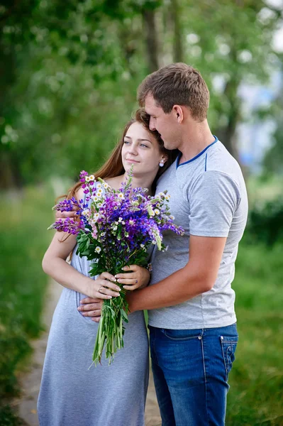 Couple amoureux du bouquet embrassent dans le parc — Photo