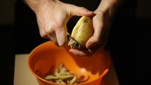 Närbild bild av en manlig hand peeling en ekologisk potatis — Stockvideo