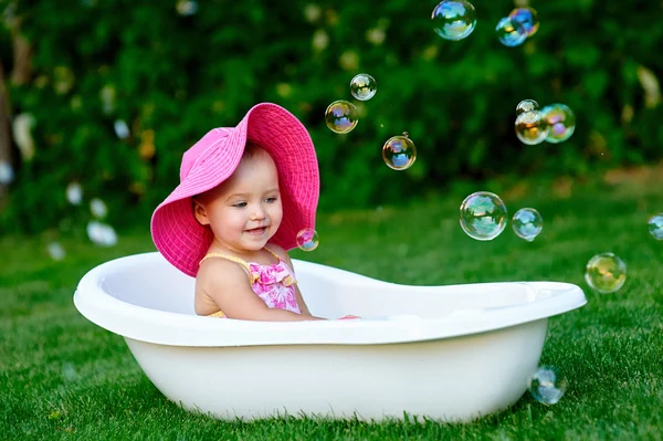 Menina toma banho em um banho com bolhas de sabão — Fotografia de Stock