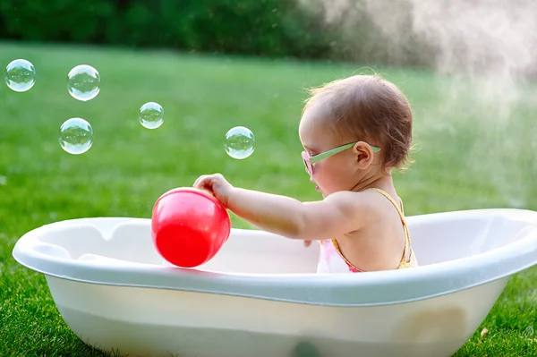Bambina si bagna in un bagno con bolle di sapone — Foto Stock