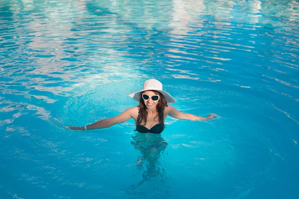 Frau mit dickem Hut entspannt sich am Pool — Stockfoto