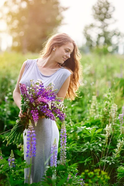 Bela mulher com buquê de flores silvestres no prado — Fotografia de Stock