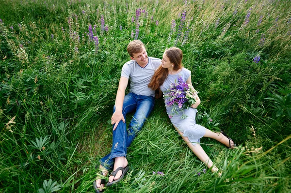 夏の草原の草に横たわっている愛のカップル — ストック写真