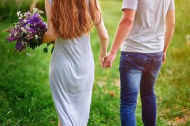 buket çiçek ile çayır üzerinde yürüme Çift